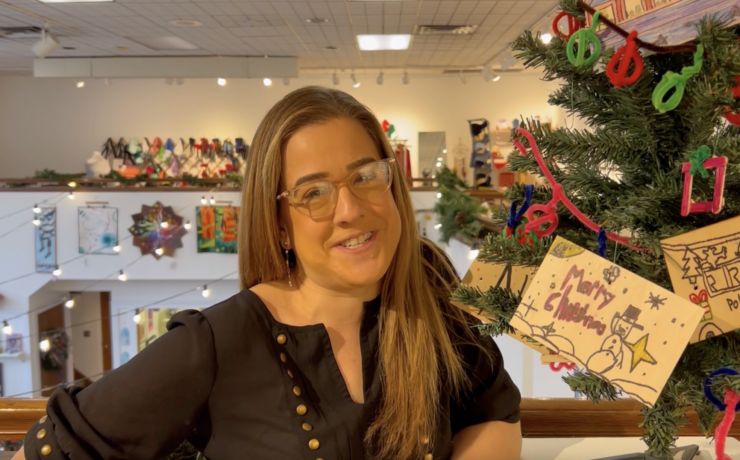 Woman in glasses next to a Christmas tree at Holiday mART