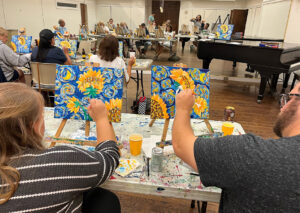 People creating paintings of sunflowers