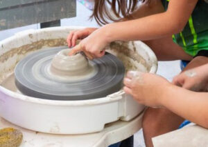 Child working with clay on a potters wheel