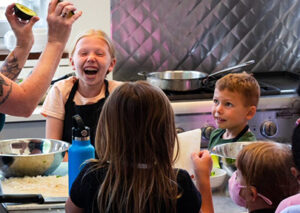 Children learning to cook in a kitchen they are laughing